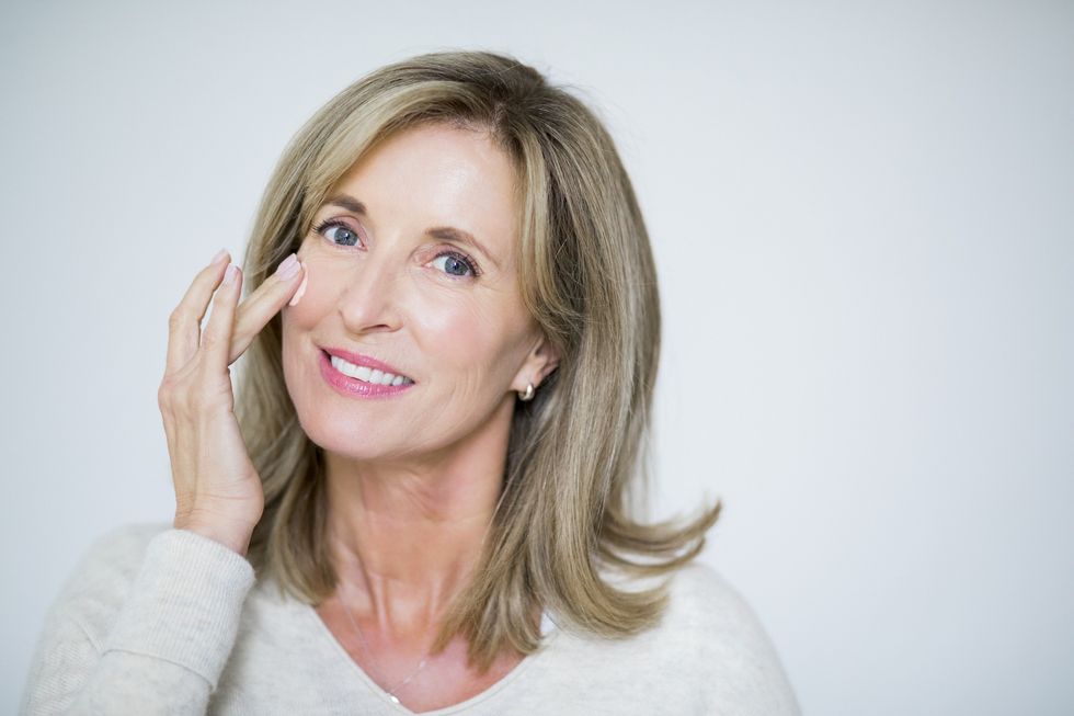 Middle-aged woman applying a skin care cream