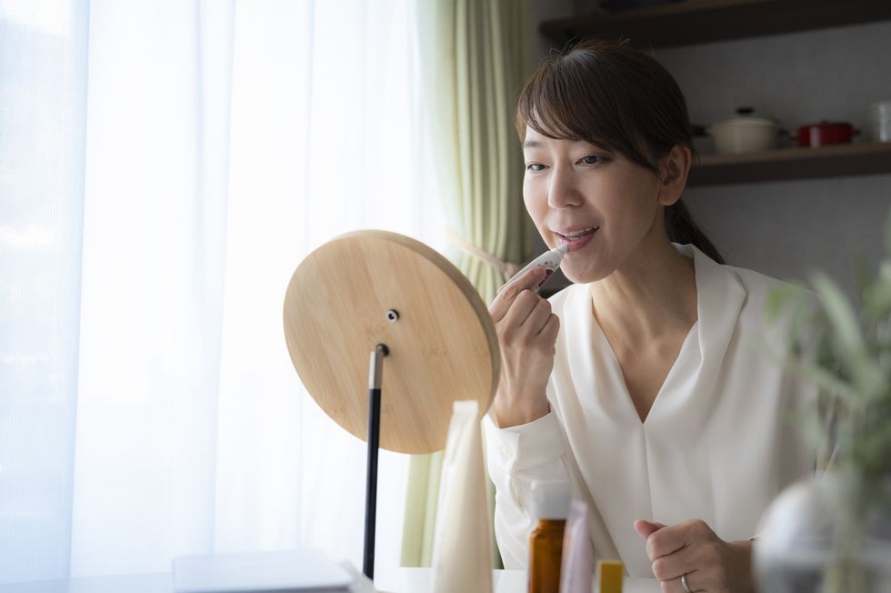 Middle-aged woman applying lip balm