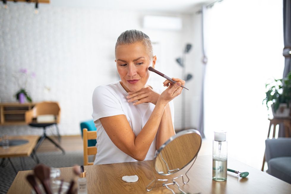 Middle-aged woman applying makeup