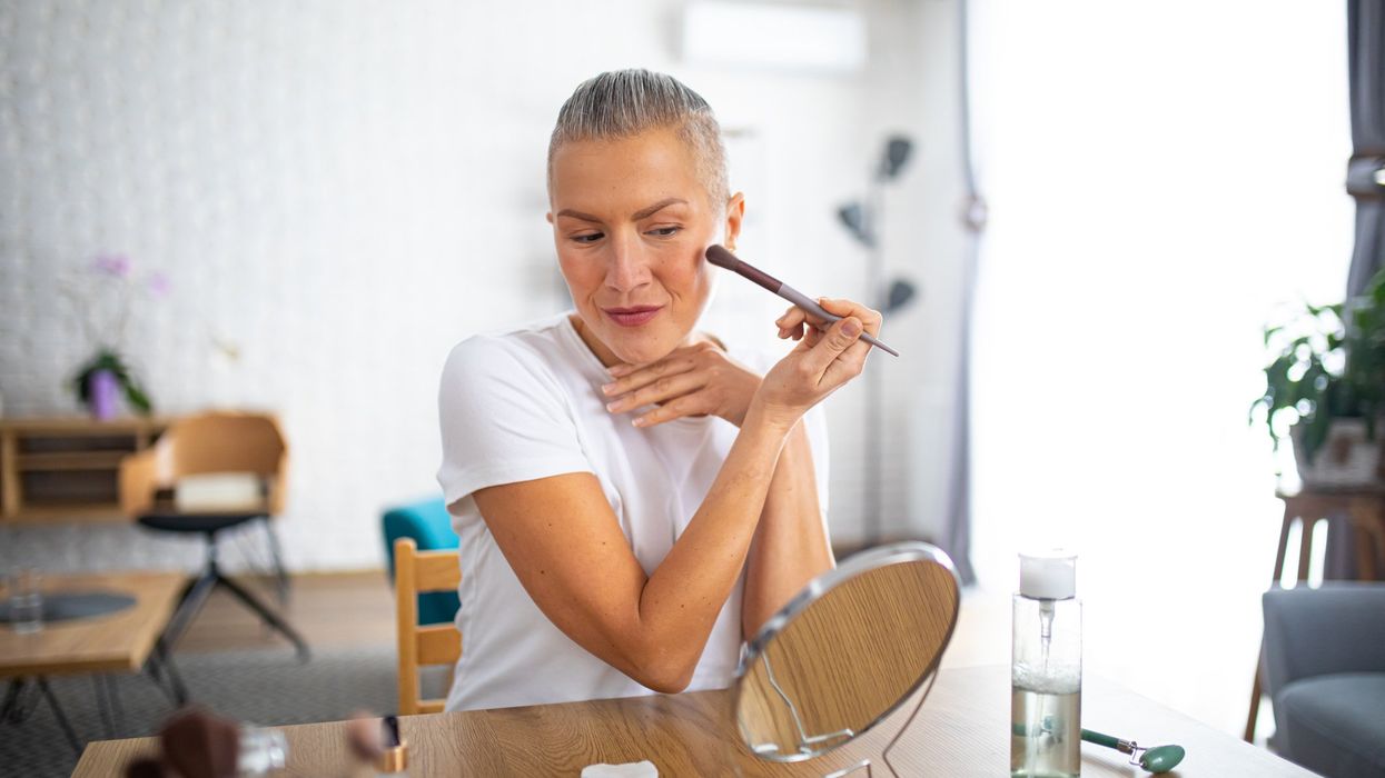 Middle-aged woman applying makeup