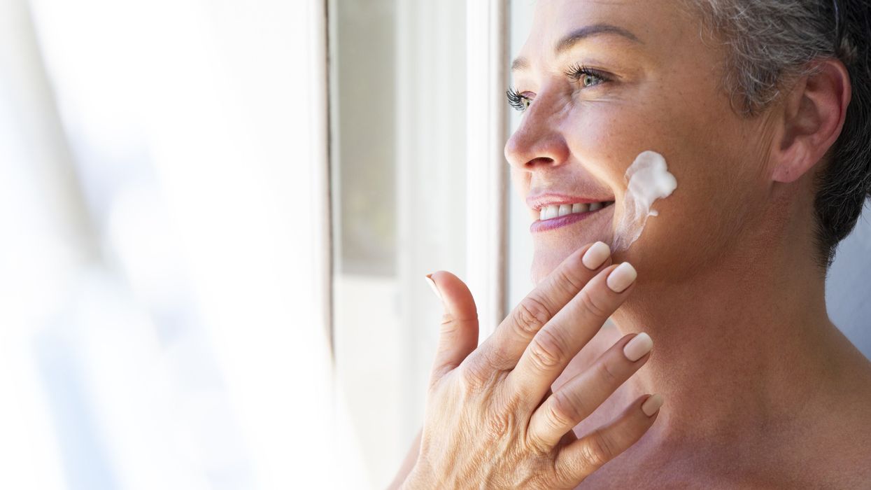 Middle-aged woman applying sunscreen