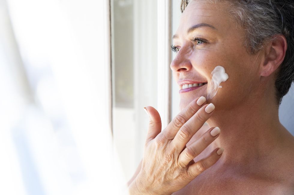Middle-aged woman applying sunscreen