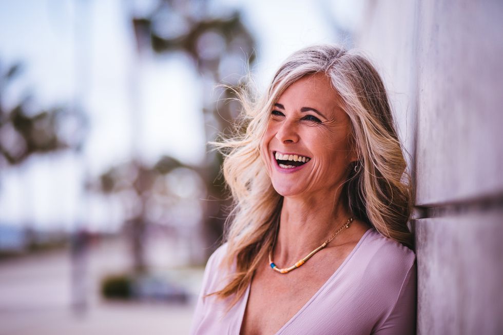 Middle aged woman laughing with face framing highlights
