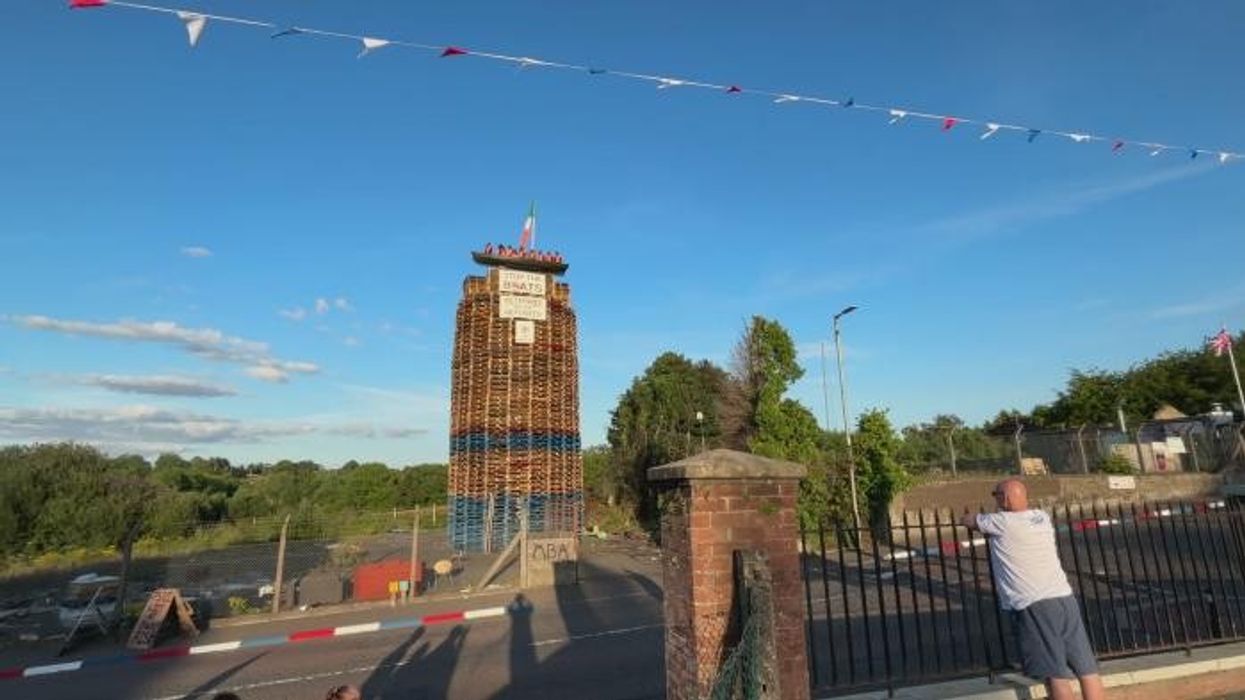 Bonfire topped with migrant boat effigy set alight as police probe hate crime