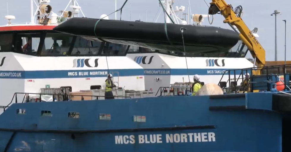 Migrant dinghy getting lifted