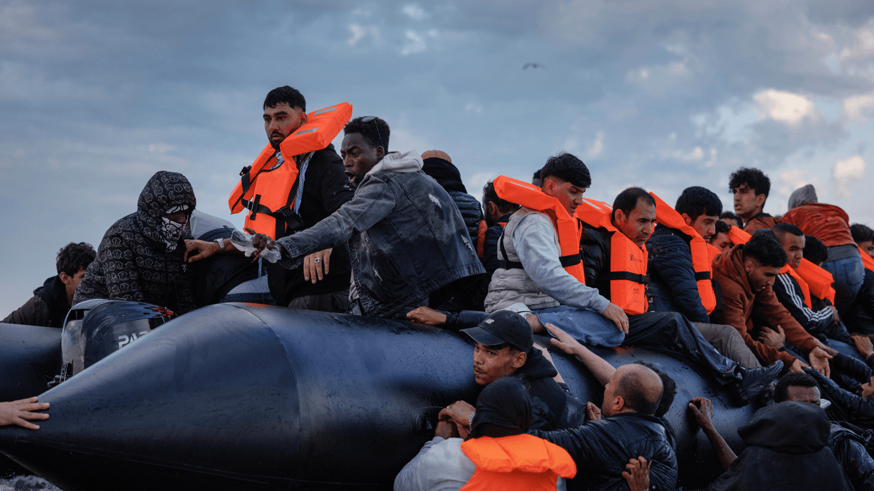 Migrant families wade into the sea