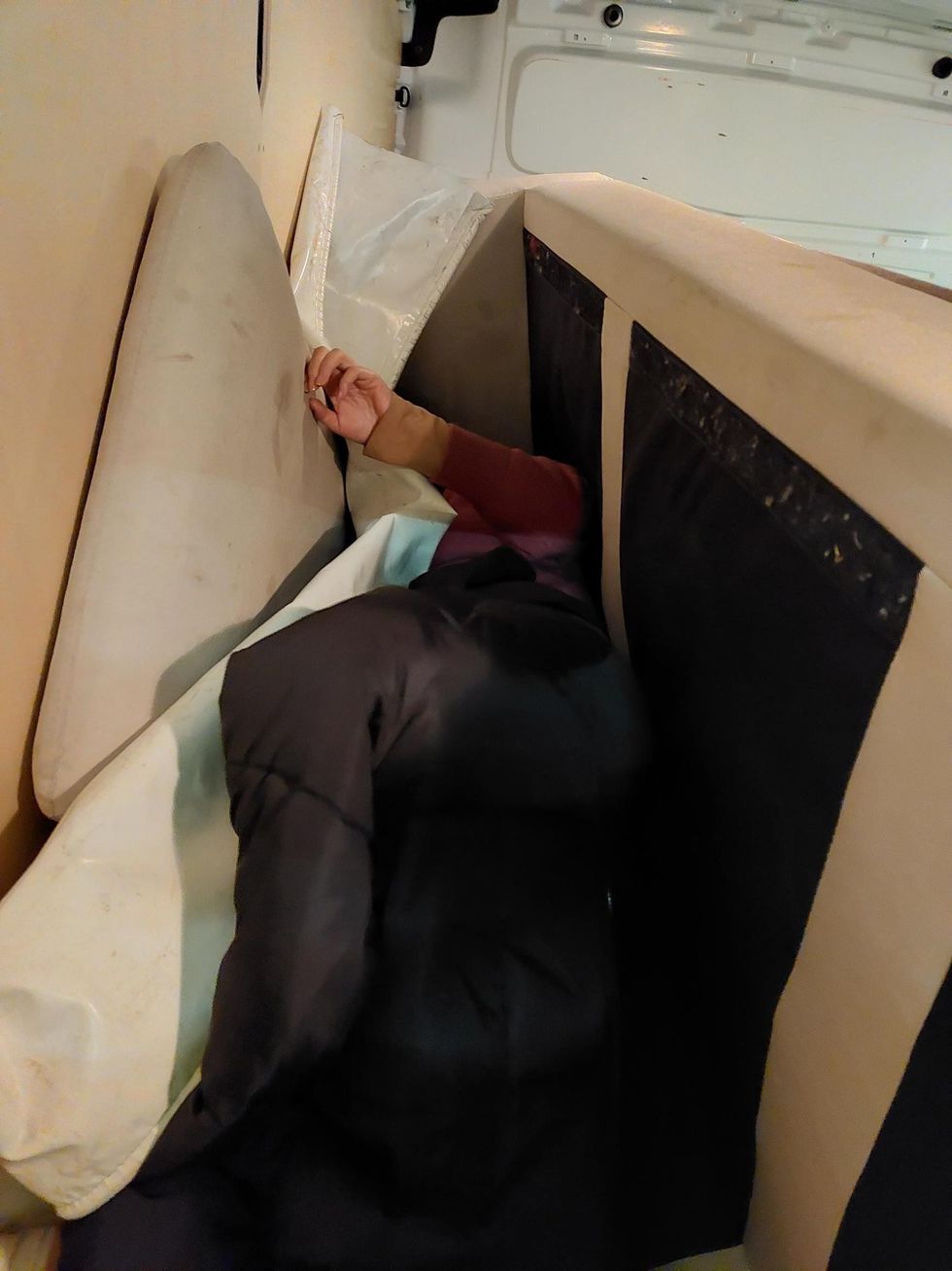 Migrant stuffed down back of a sofa