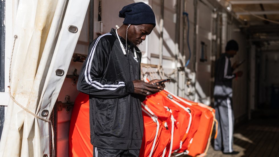 Migrant using phone onboard the rescue ship 'Ocean Viking'