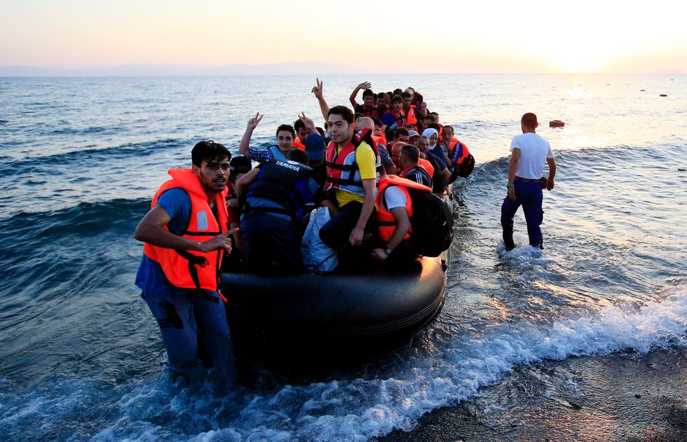 Migrants and refugees in a rubber dinghy arrive on the beach at Psalidi near Kos Town, Greece.