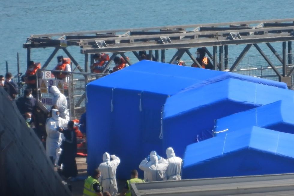 Migrants being escorted into the tents