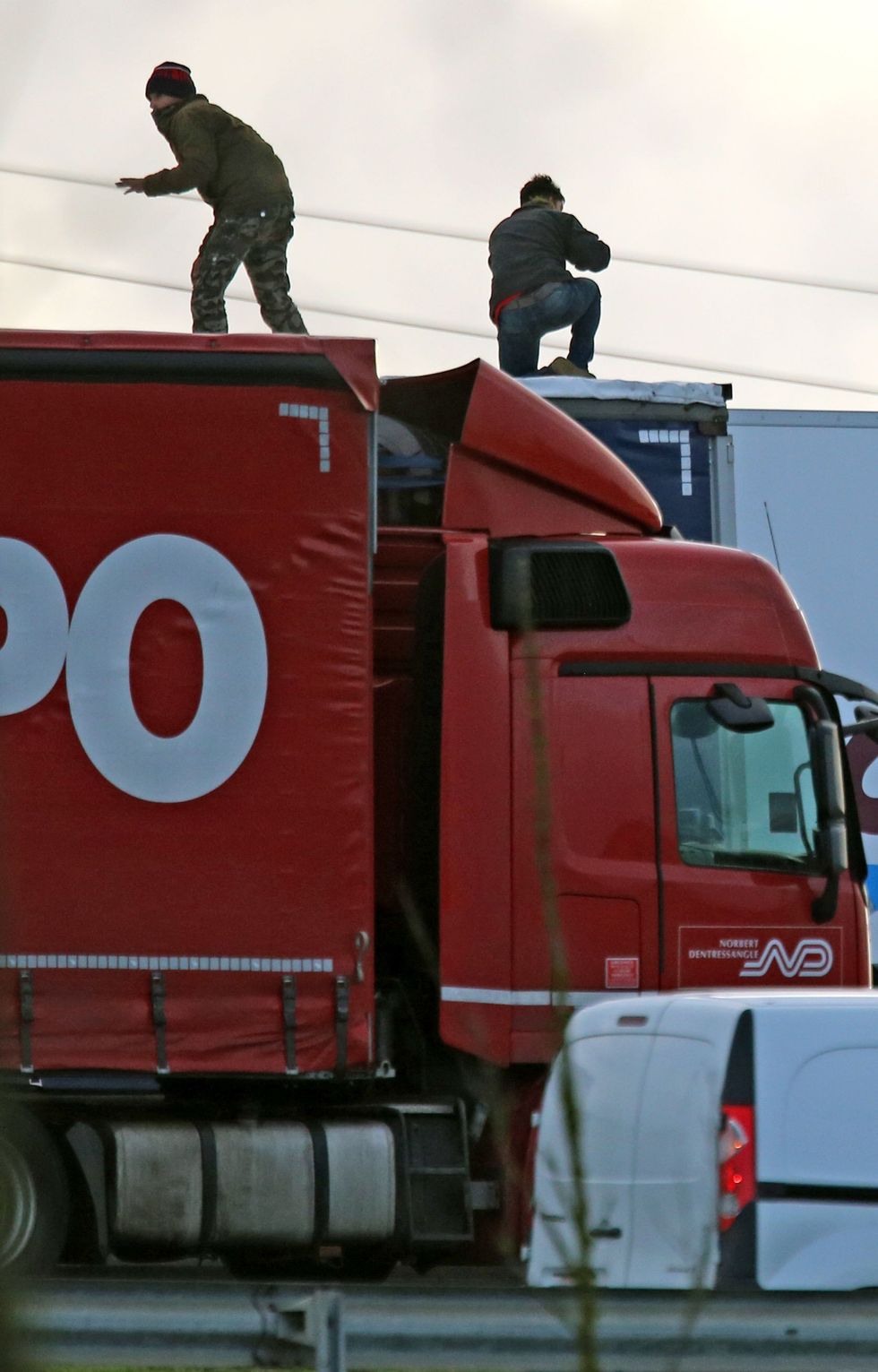 migrants climbing on lorries