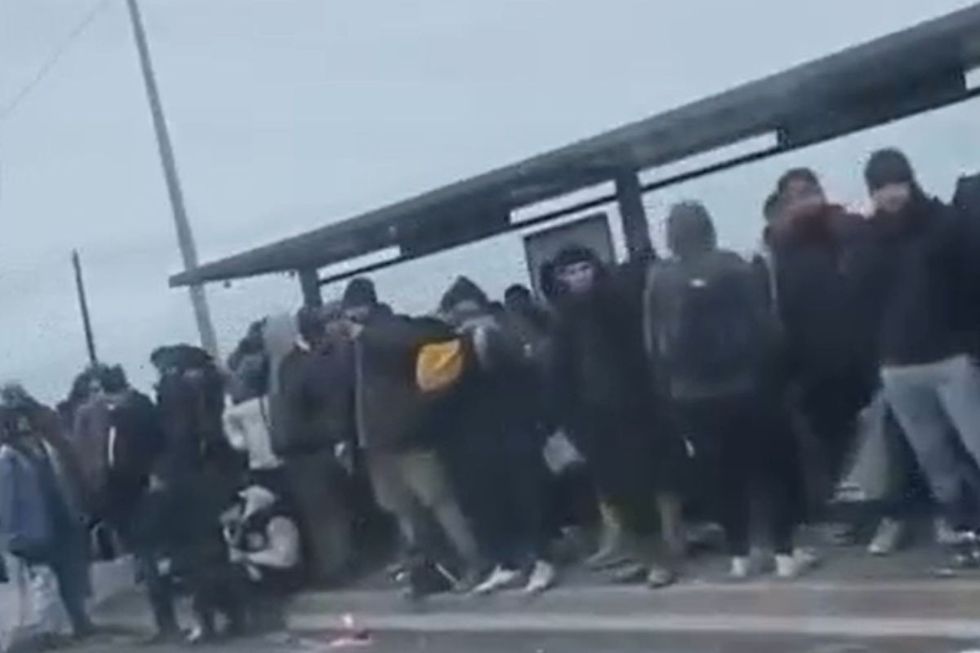 Migrants gather at a bus stop in northern France