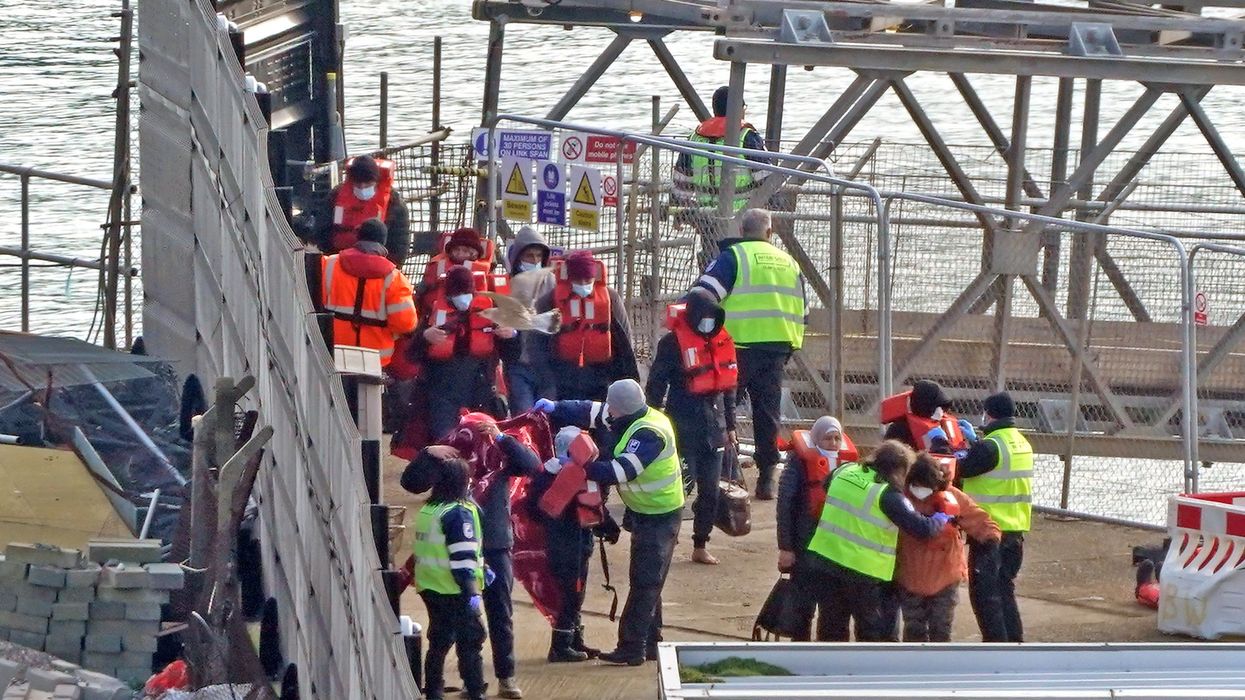 Migrants in lifejackets with border force control in Dover