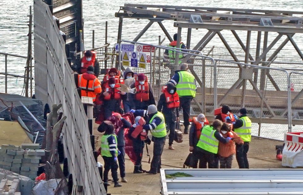 Migrants in lifejackets with border force control in Dover
