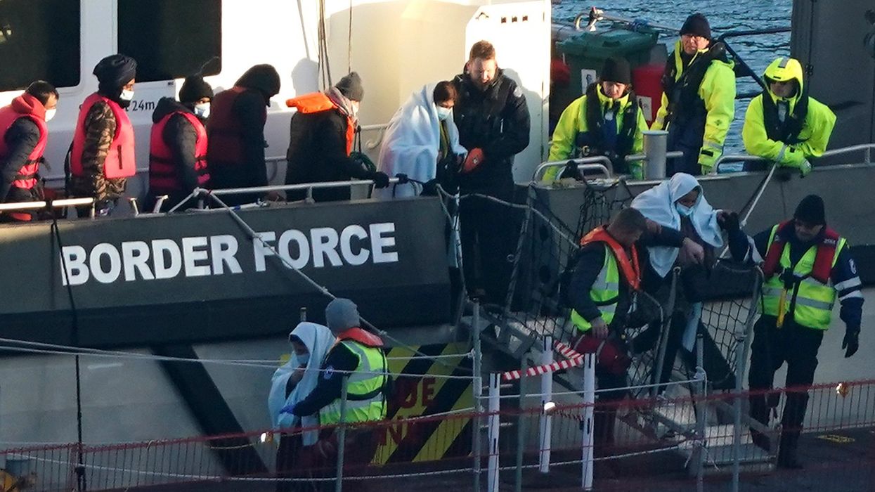 Migrants in lifejackets with border force control in Dover