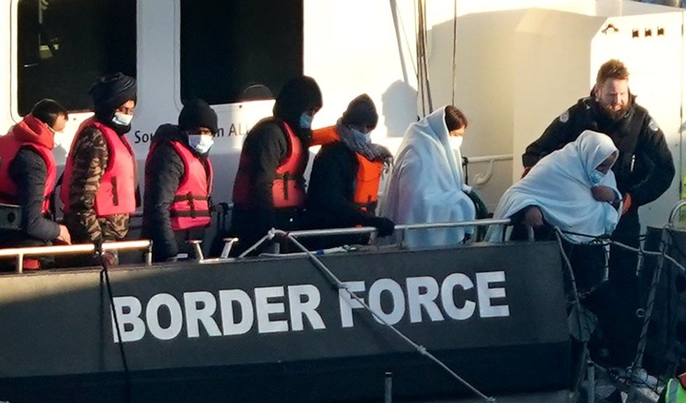 Migrants in lifejackets with border force control in Dover