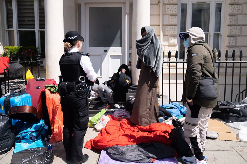Migrants outside an asylum hotel in London