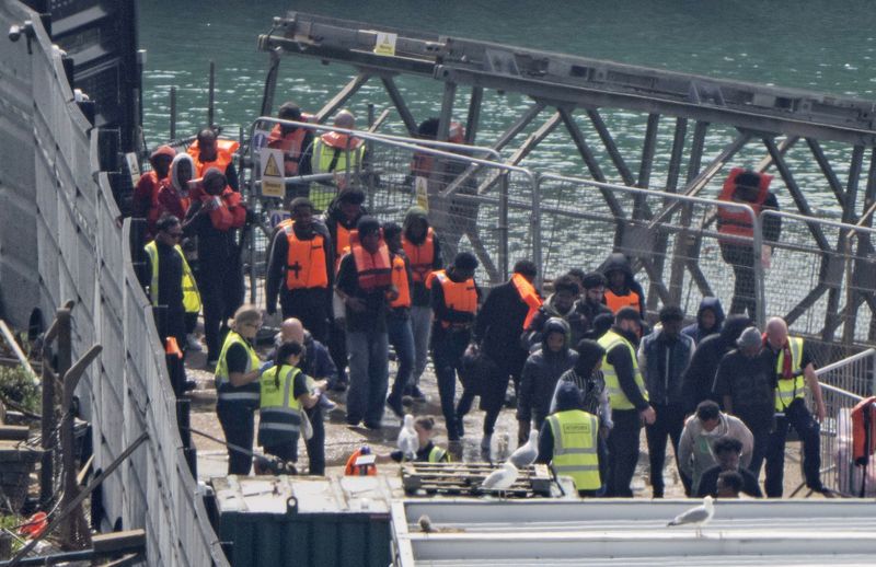 Migrants picked up by UK border force in the Channel disembark in Dover