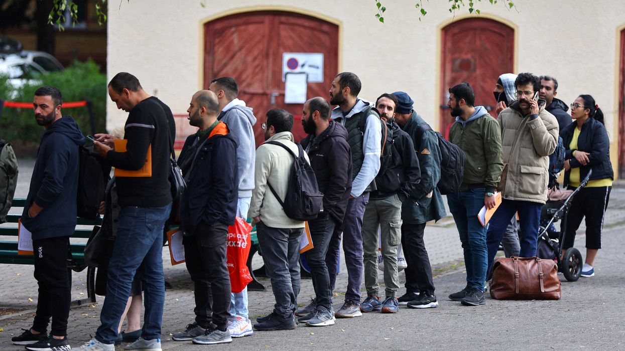  Migrants queue in a waiting area at the arrival centre for asylum seekers in Reinickendorf district, Berlin