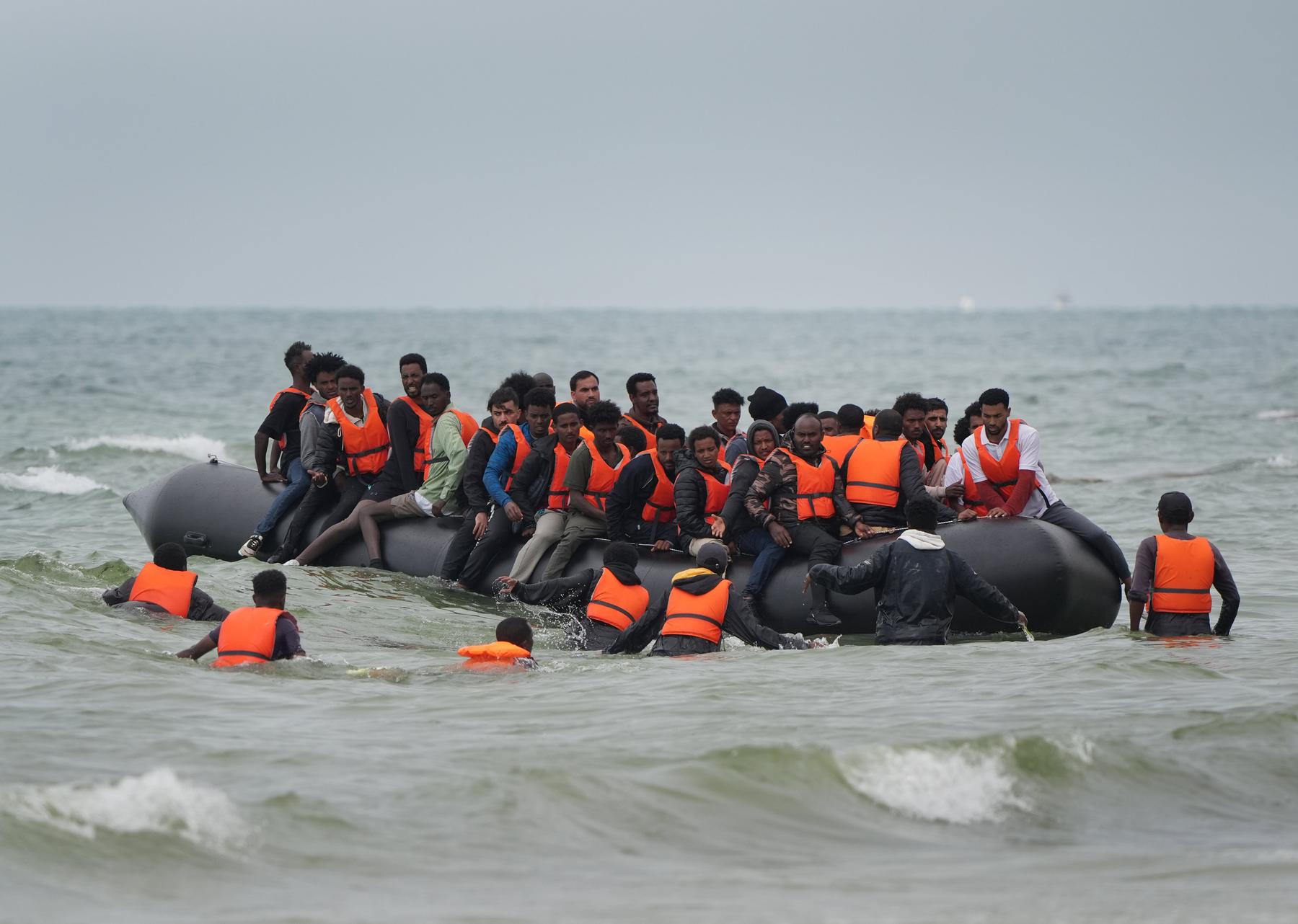 Migrants scramble to board a small boat near Wimereux in France