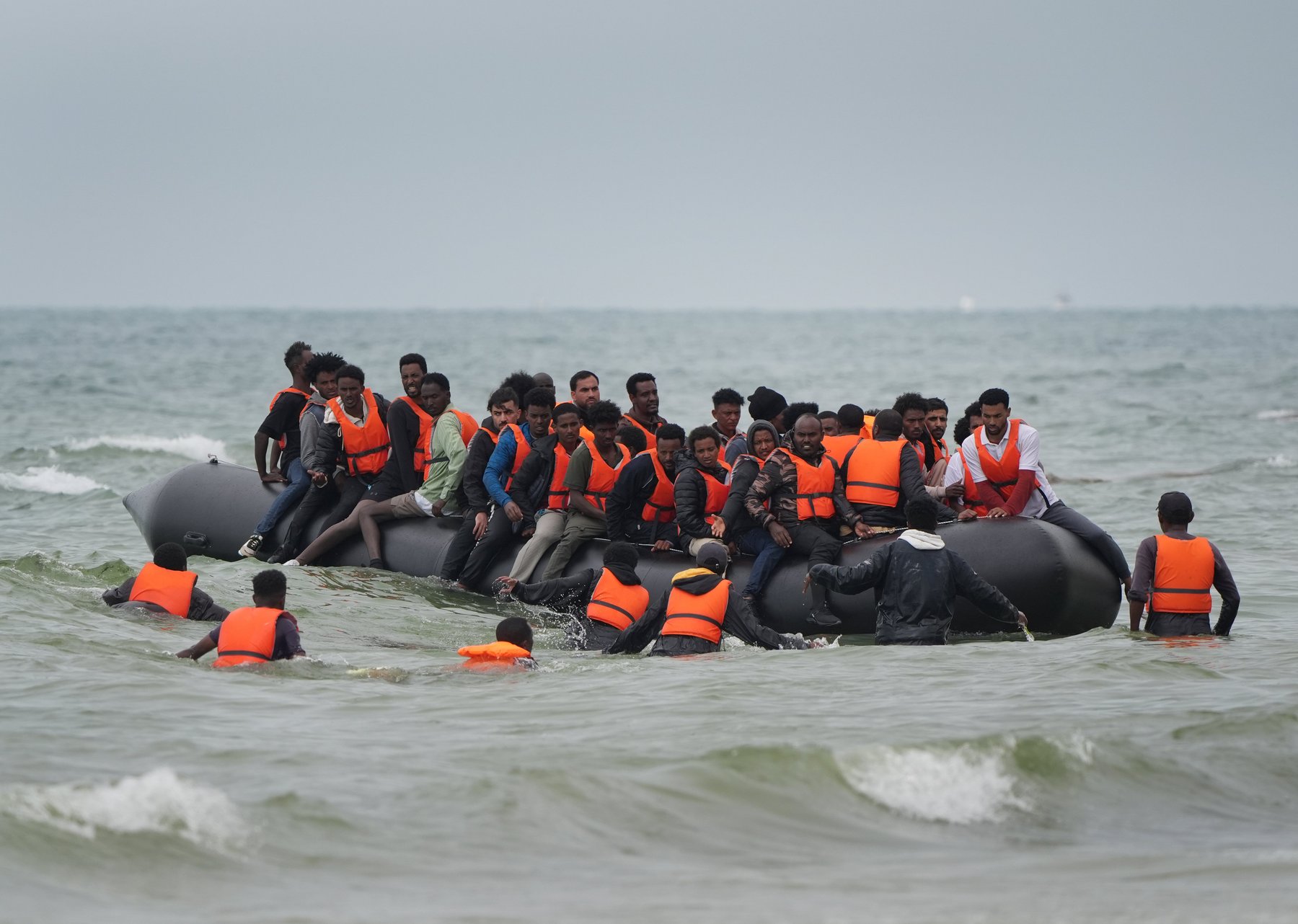 Migrants scramble to board a small boat near Wimereux in France