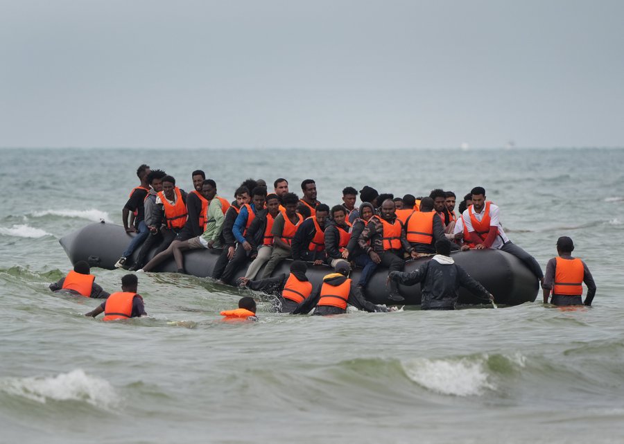 Migrants scramble to board a small boat near Wimereux in France