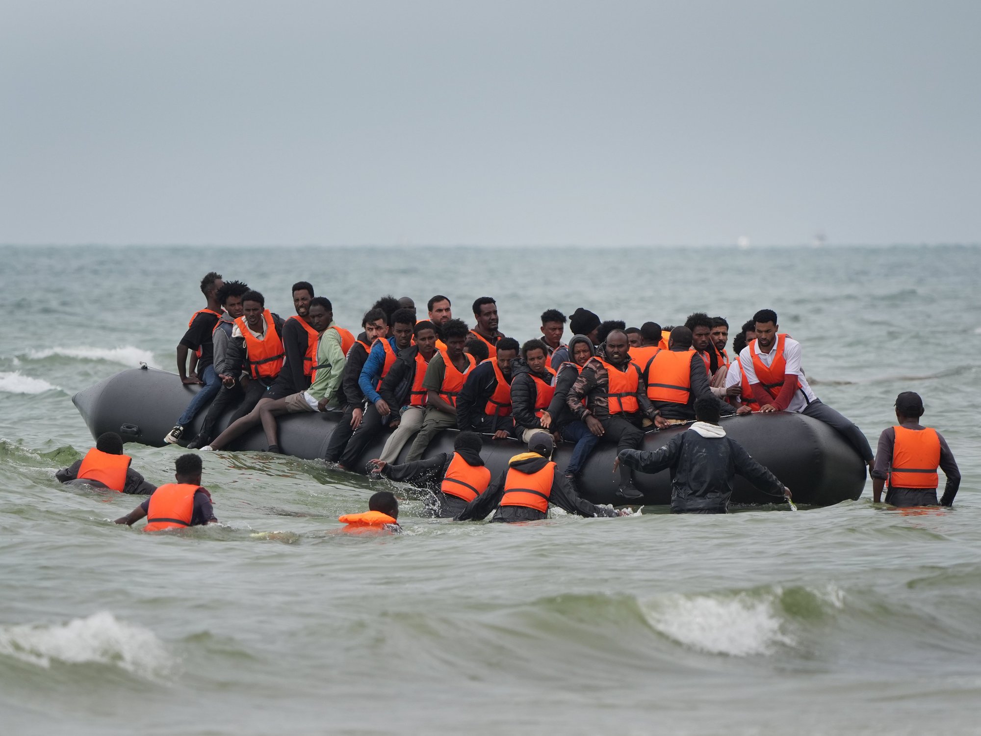 Migrants scramble to board a small boat near Wimereux in France