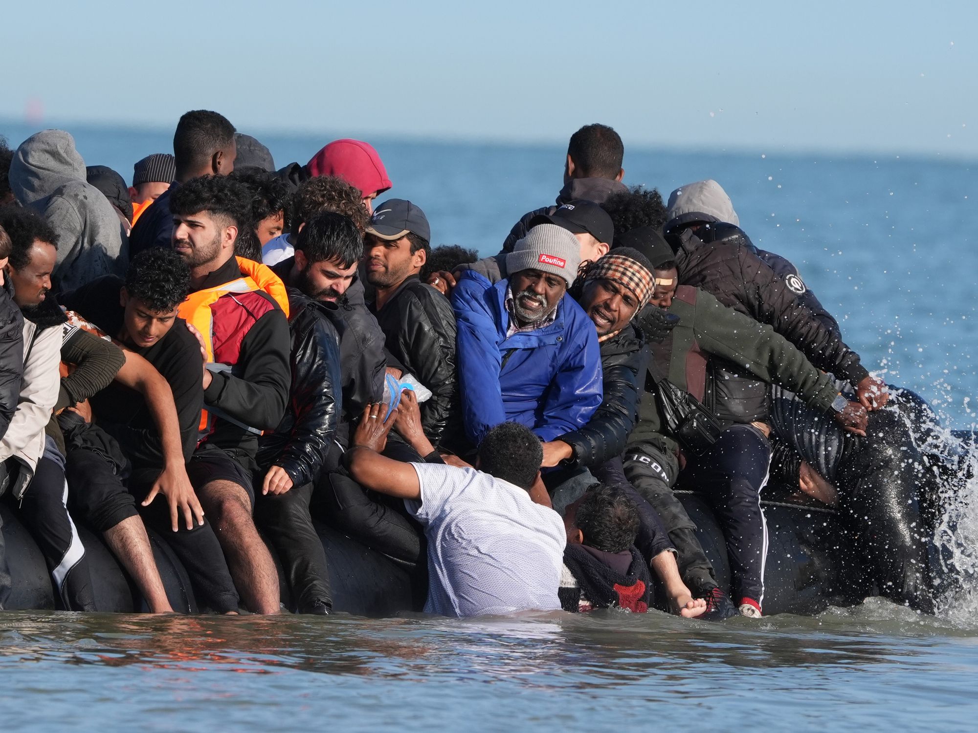 Migrants struggling to board a small boat bound for Britain