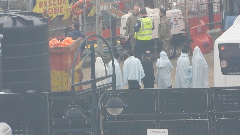 Migrants wait after arriving in England.