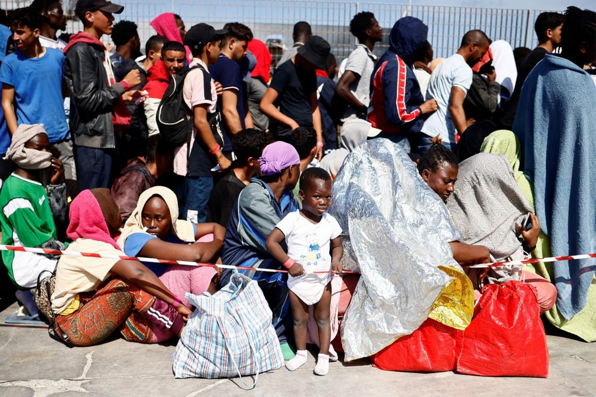 Migrants wait at the port on the Sicilian island of Lampedusa, Italy.