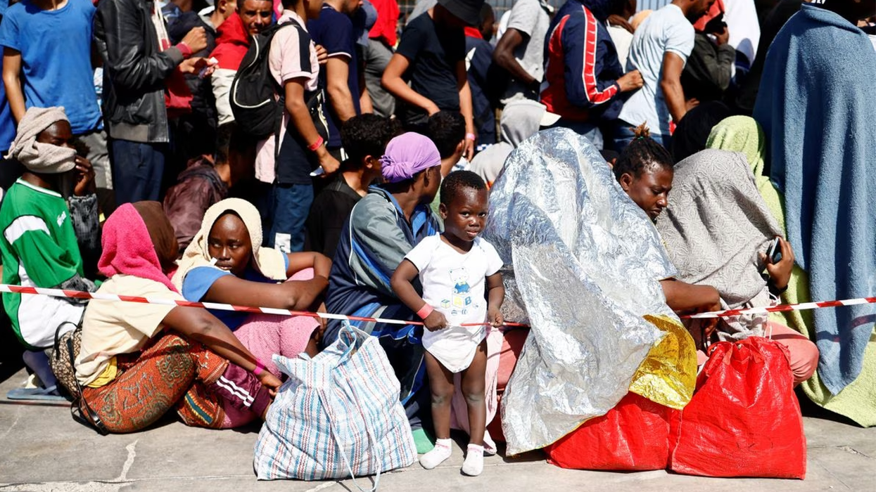 Migrants wait at the port on the Sicilian island of Lampedusa, Italy.