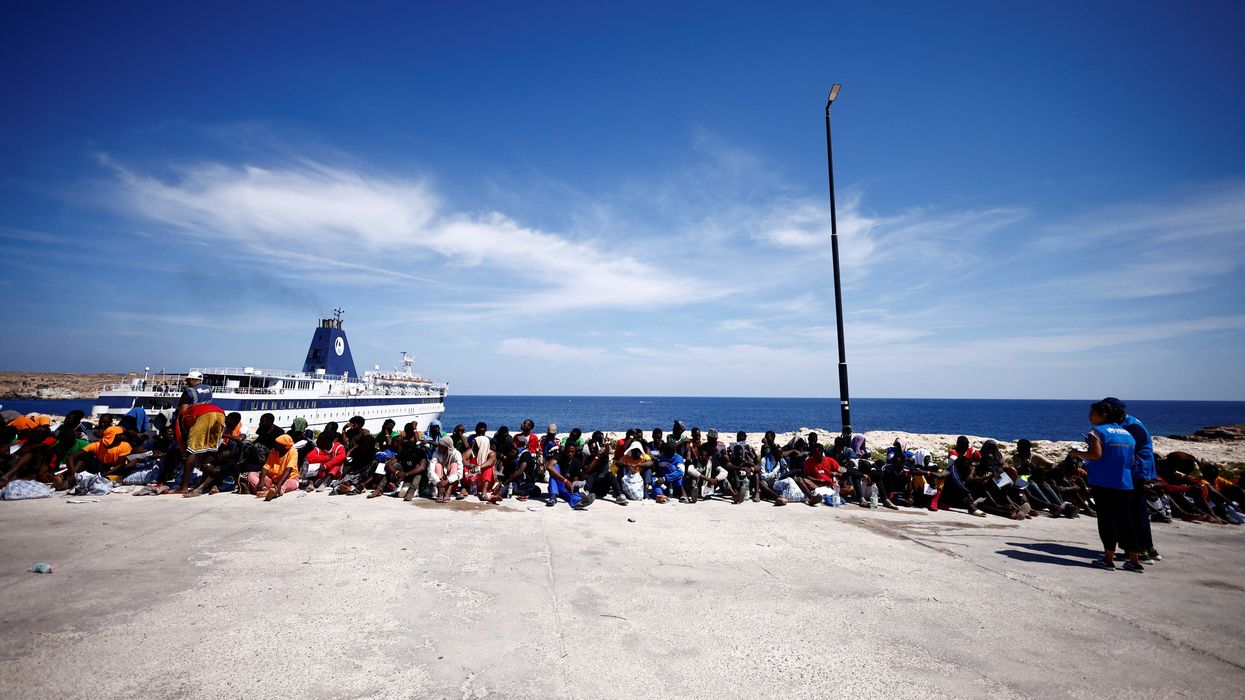 Migrants wait near the port to be transferred to the mainland, on the Sicilian island of Lampedusa, Italy