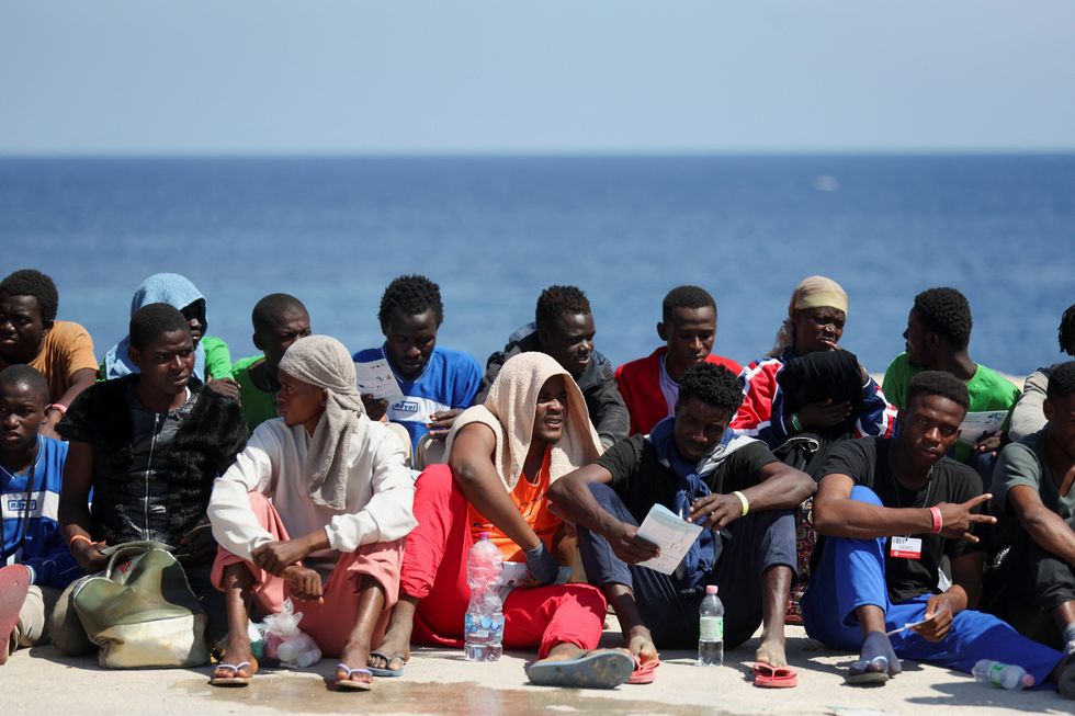 Migrants waiting outside the local reception centre