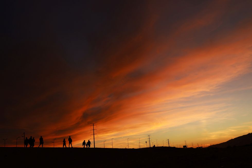 Migrants walk near the Rio Bravo river