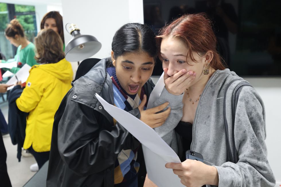 Milan (left) and Sasha (right) celebrate after receiving their GCSE results at Notting Hill and Ealing High School in Ealing, London
