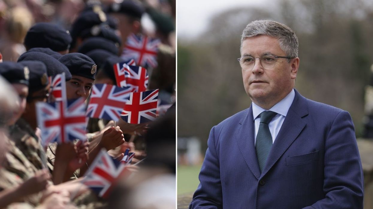 Military personnel waving union jack flags and Sir Robert Buckland