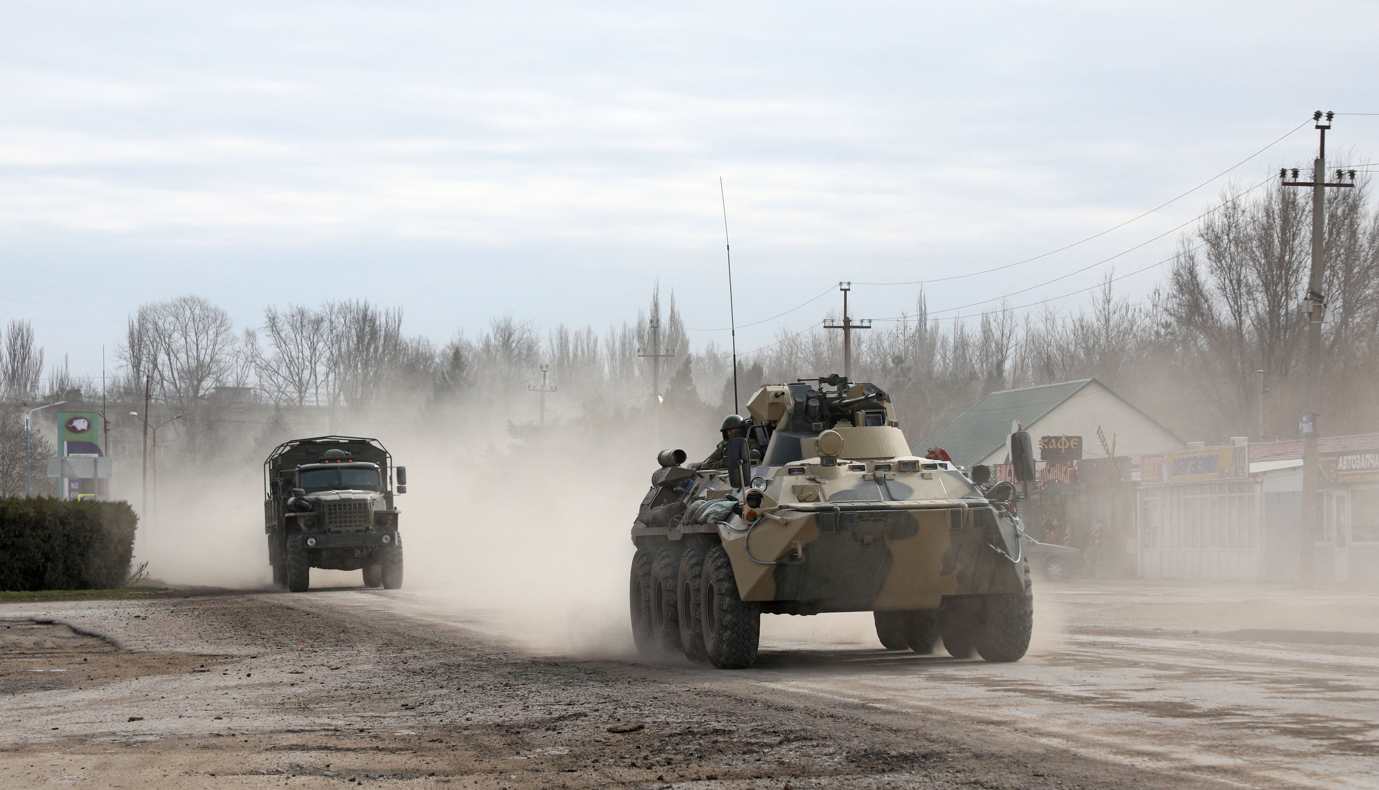 Military vehicles drive along a street, after Russian President Vladimir Putin authorised a military operation in eastern Ukraine, in the town of Armyansk, Crimea, February 24, 2022. REUTERS/Stringer