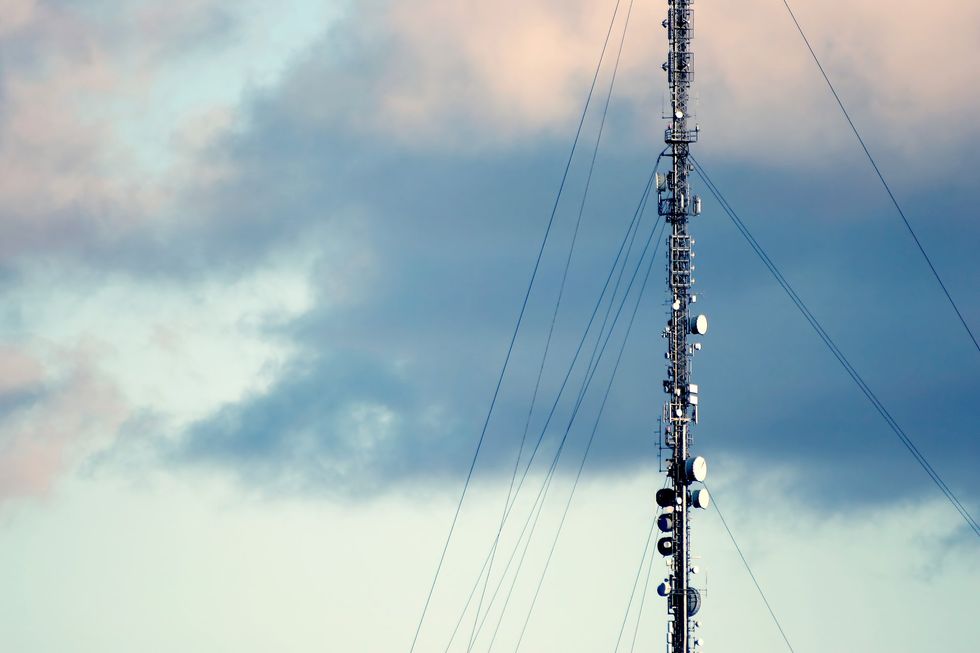 mobile network mast with 4G and 5G connections pictured against a stormy sky
