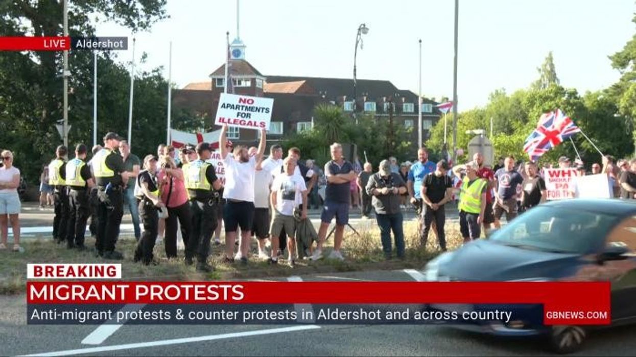 Moment Stand Up to Racism protesters shove placards in front of Charlie Peters during live GB News broadcast
