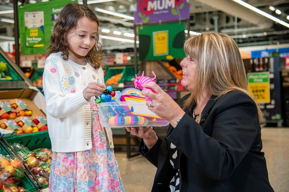Morrisons staff worker with child and sensory support box