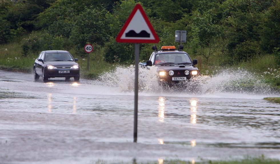 Motorists drive through deep water as heavy rain caused flooding near Beverley, in North East Yorkshire