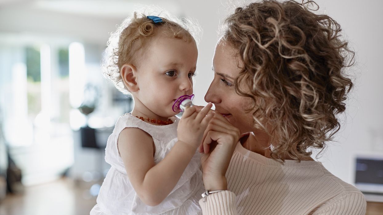 Mum holding baby who is using a pacifier