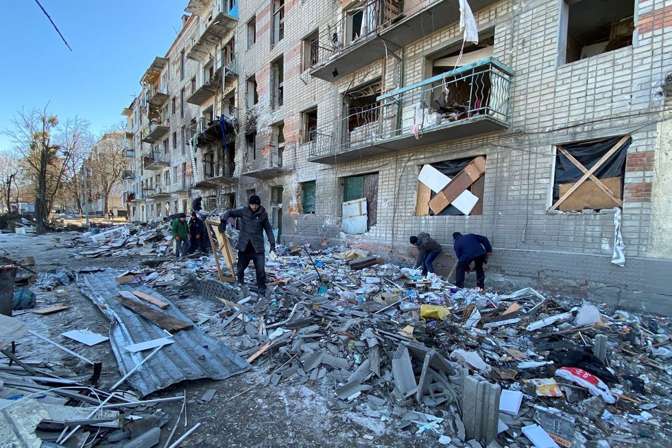 Municipal workers and volunteers remove debris of a damaged residential building, as Russia's attack on Ukraine continues, in Kharkiv, Ukraine March 21, 2022. REUTERS/Vitalii Hnidyi