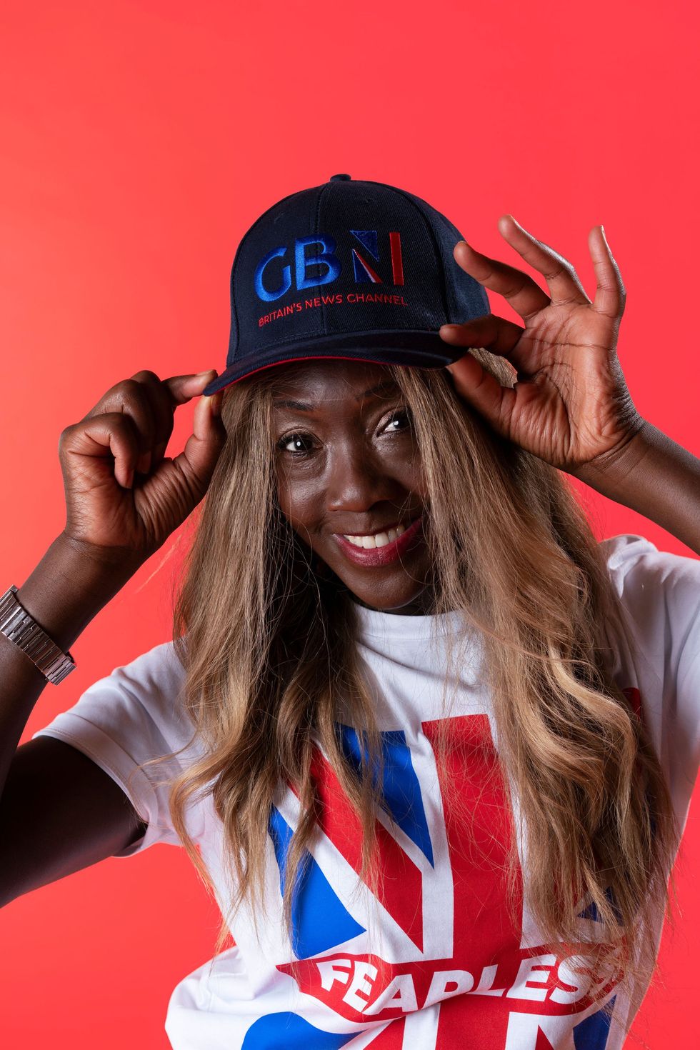 Nana Akua wearing a fearless t-shirt and showing one of the mugs from the same collection