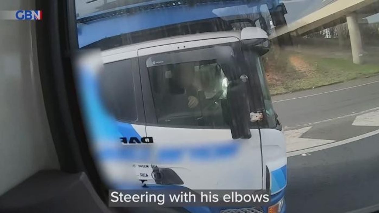 Driver caught using his ELBOW to steer huge lorry while on motorway