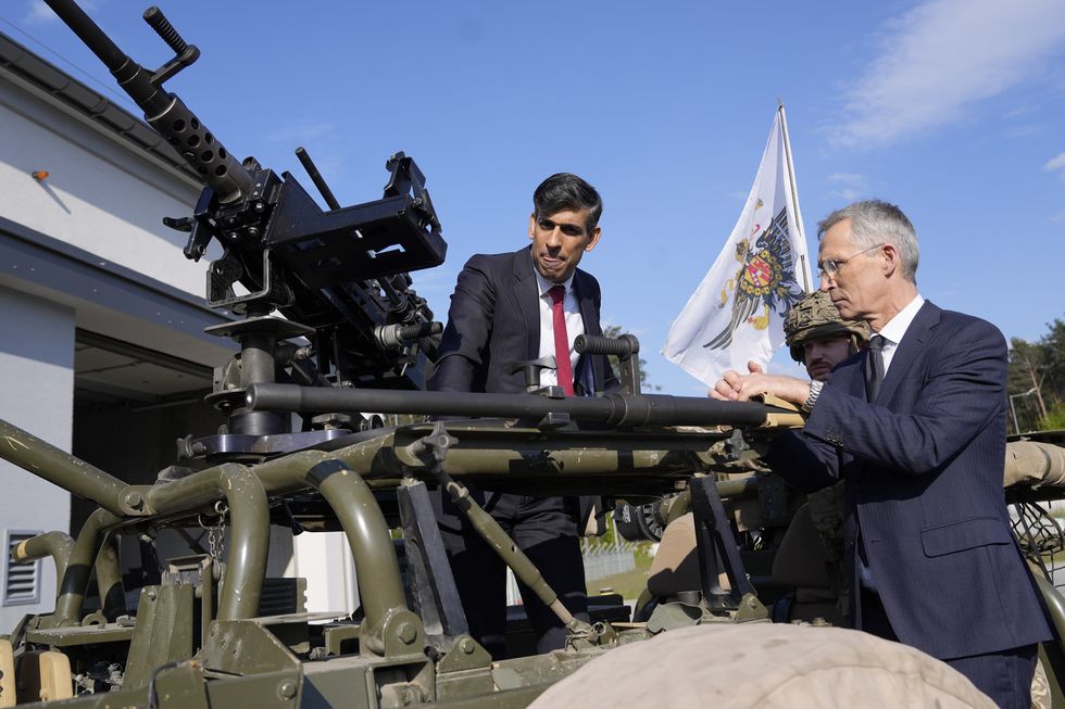 NATO Secretary General Jens Stoltenberg (right) and Prime Minister Rishi Sunak inspect weaponry at the Warsaw Armoured Brigade