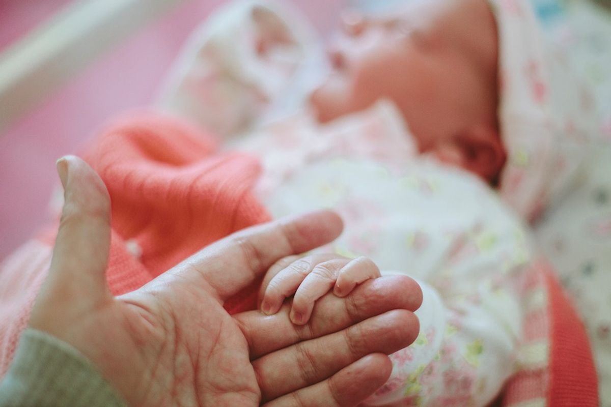Newborn baby's hand in mother's hand