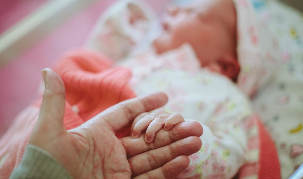 Newborn baby's hand in mother's hand