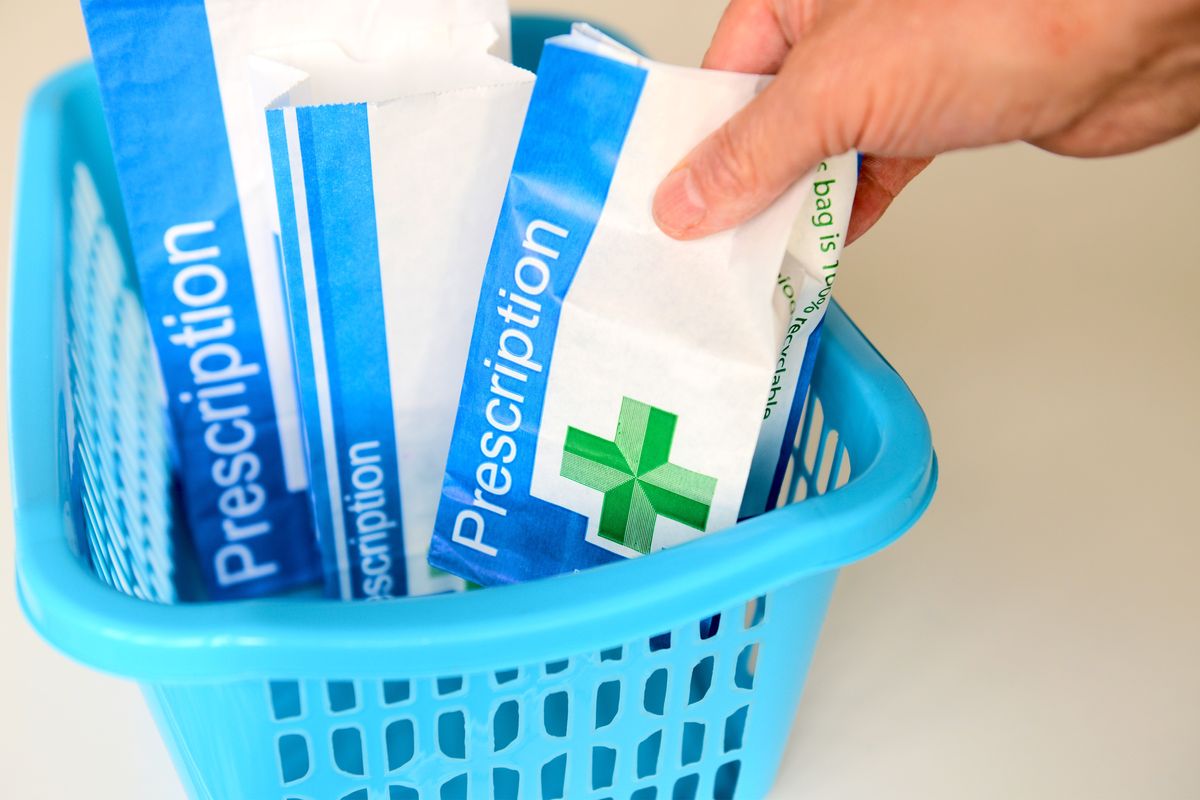NHS prescription packet in basket at pharmacist
