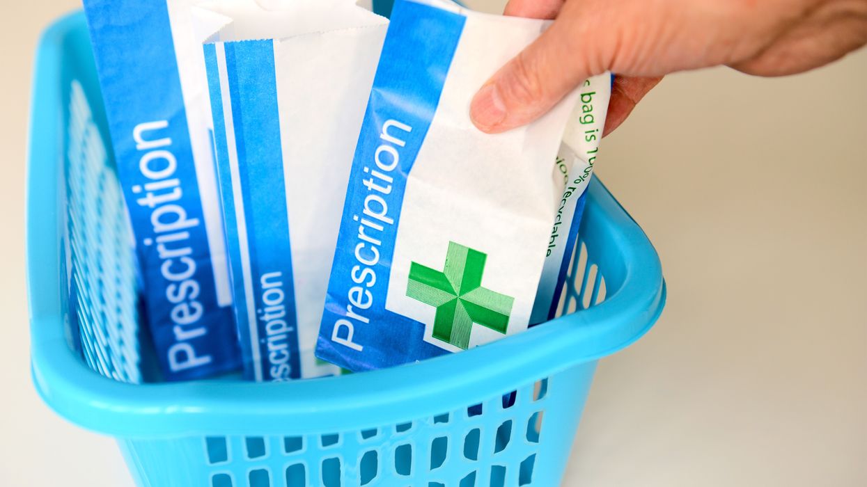NHS prescription packet in basket at pharmacist